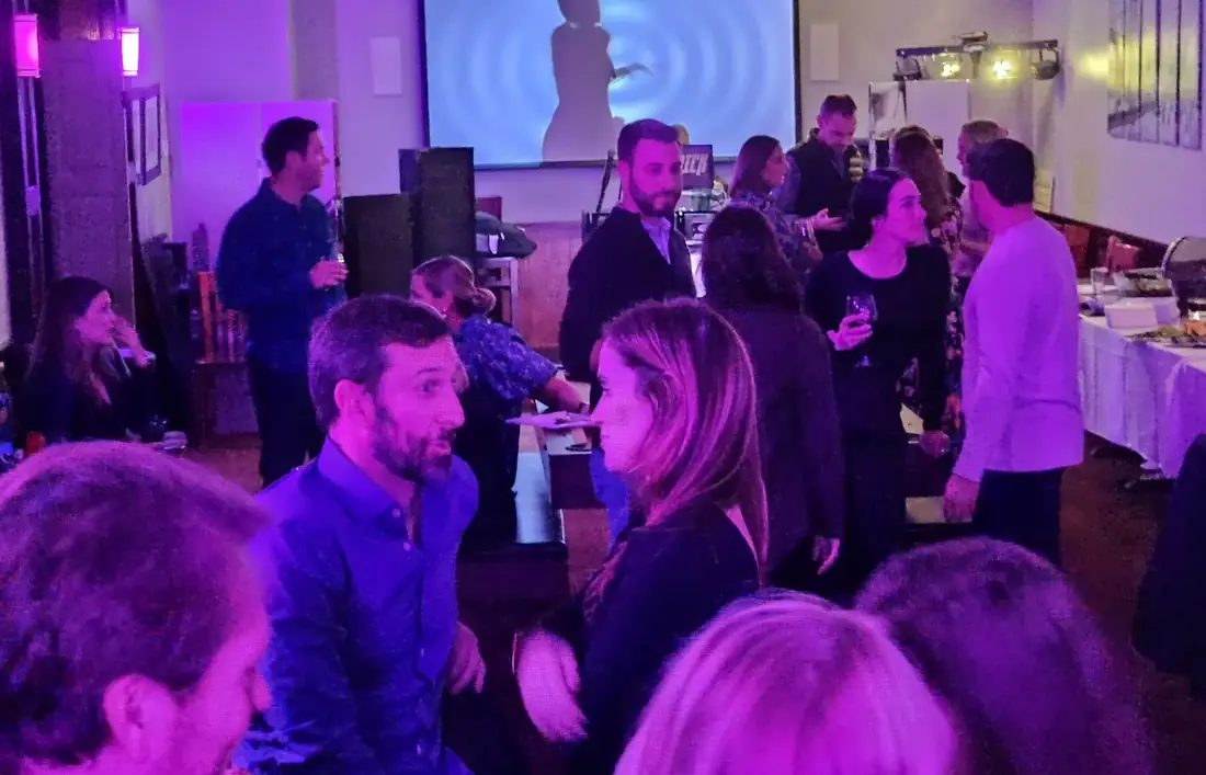 A busy night at 660 LIVE with a DJ playing, projection on the wall and a full room of guests.