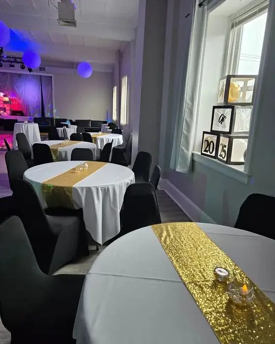 Round tables in white linen with gold sequin runners set in The Loft at 660 beside the dance floor.