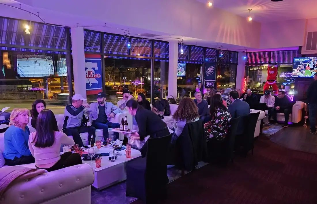 Big screens above the lounge at 660 LIVE showing hockey and UFC, guests on the sofas below.