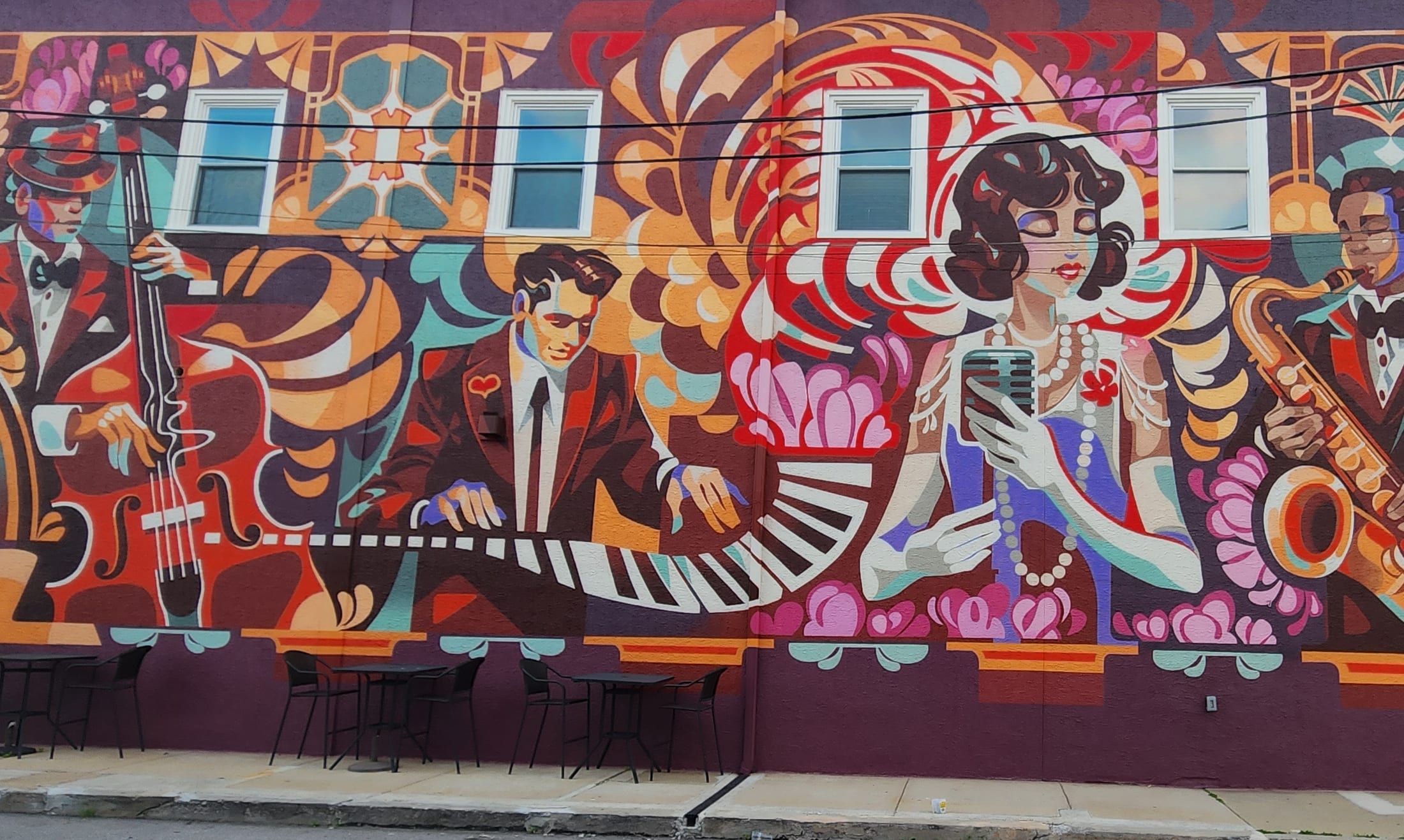 The full length of the mural along the building at 660 E Lancaster Avenue — upright bass, piano, singer and saxophone across an art deco backdrop